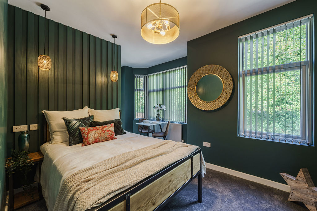 Green-panelled bedroom with bay window